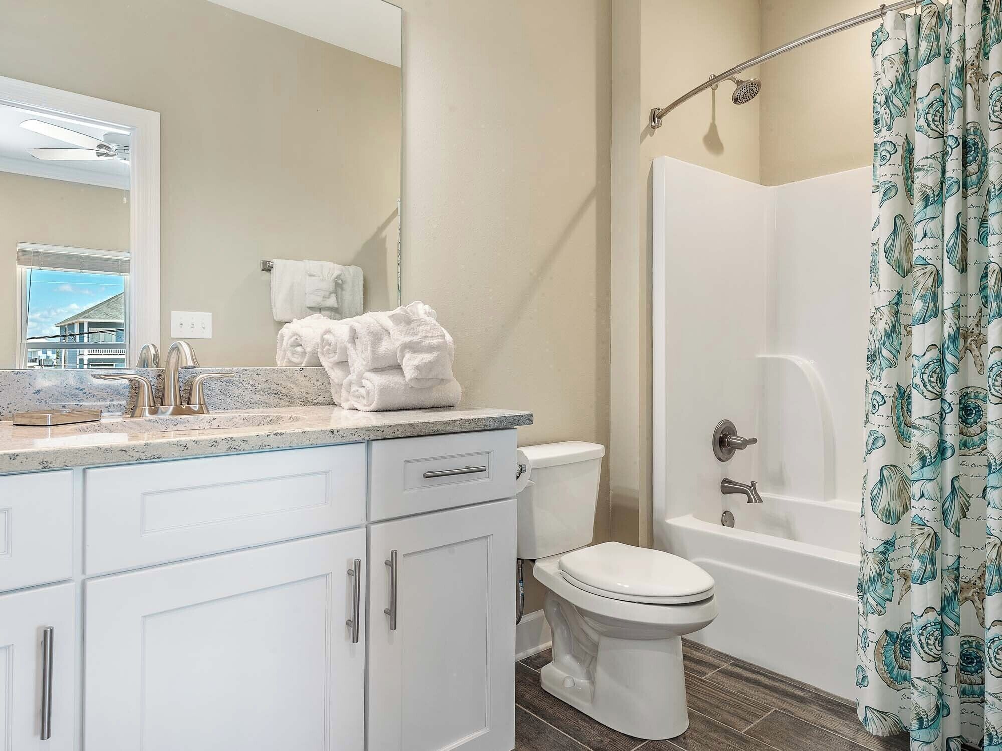 A bathroom with a white sink, a toilet, and a shower with a curtain.