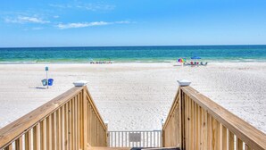 A wooden boardwalk leading to a sandy beach with a clear blue sky. - Arena Blanca by Southern Vacation Rentals (Gulf Shores)