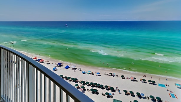 A beach with clear turquoise waters and a white sandy shore. - Emerald Isle by Resort Collection (Panama City Beach)