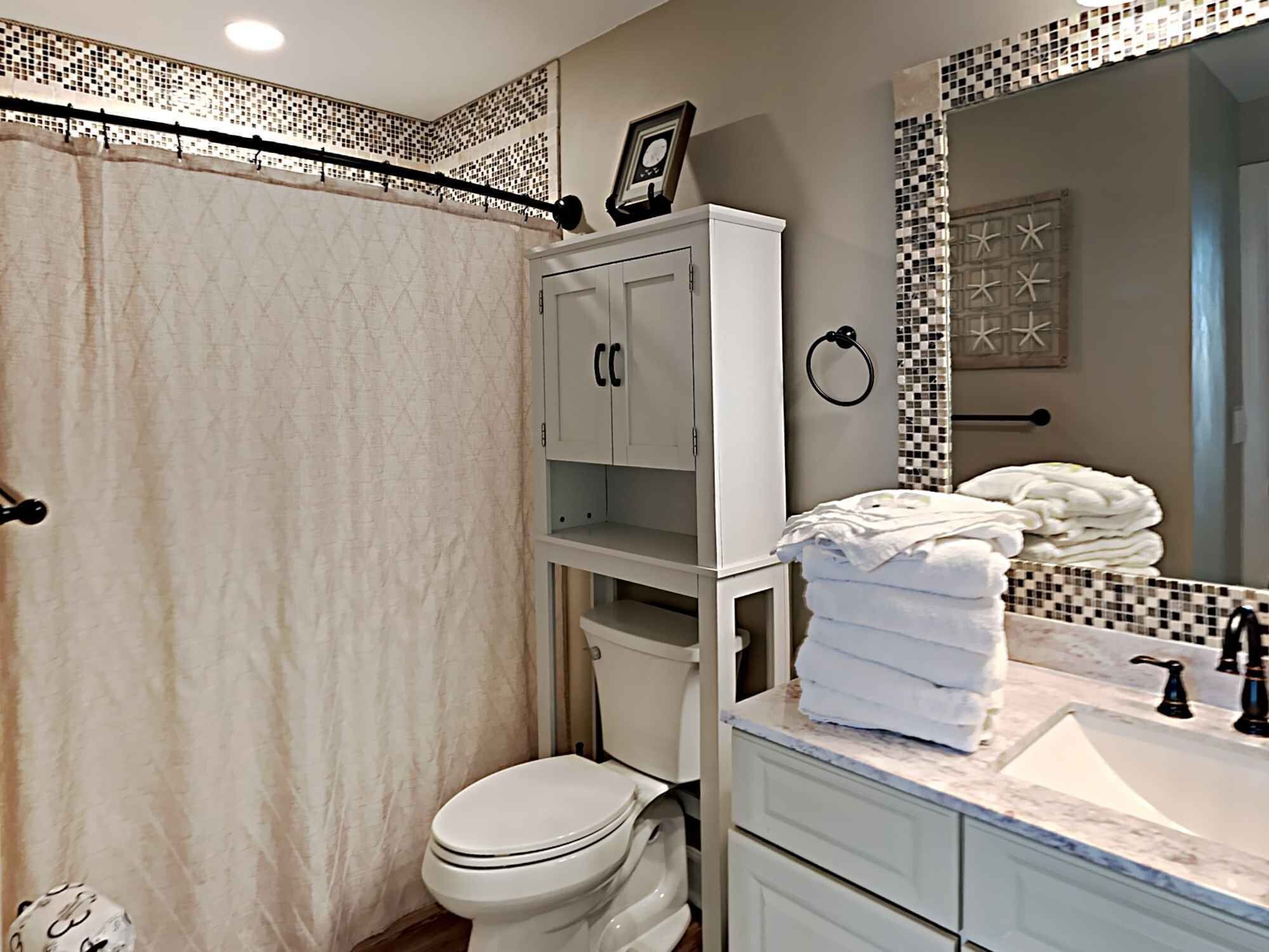 A bathroom with a toilet, a sink, and a shower area.