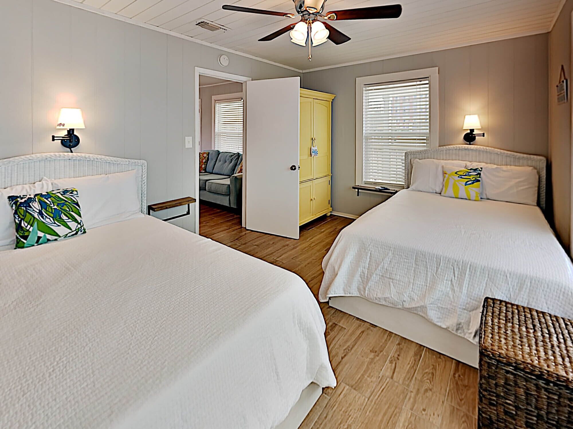 A bedroom with two beds, a ceiling fan, and a walk-in closet.