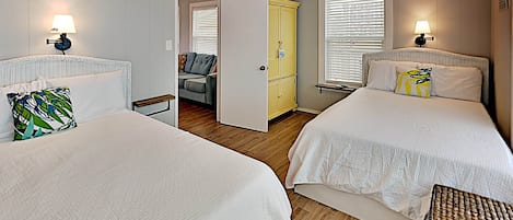 A bedroom with two beds, a ceiling fan, and a walk-in closet.