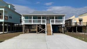 A beachfront house with a two-story balcony, a covered porch, and a concrete driveway. - Big Blue by Southern Vacation Rentals (Gulf Shores)