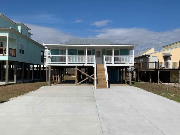 A beachfront house with a two-story balcony, a covered porch, and a concrete driveway. - Big Blue by Southern Vacation Rentals (Gulf Shores)