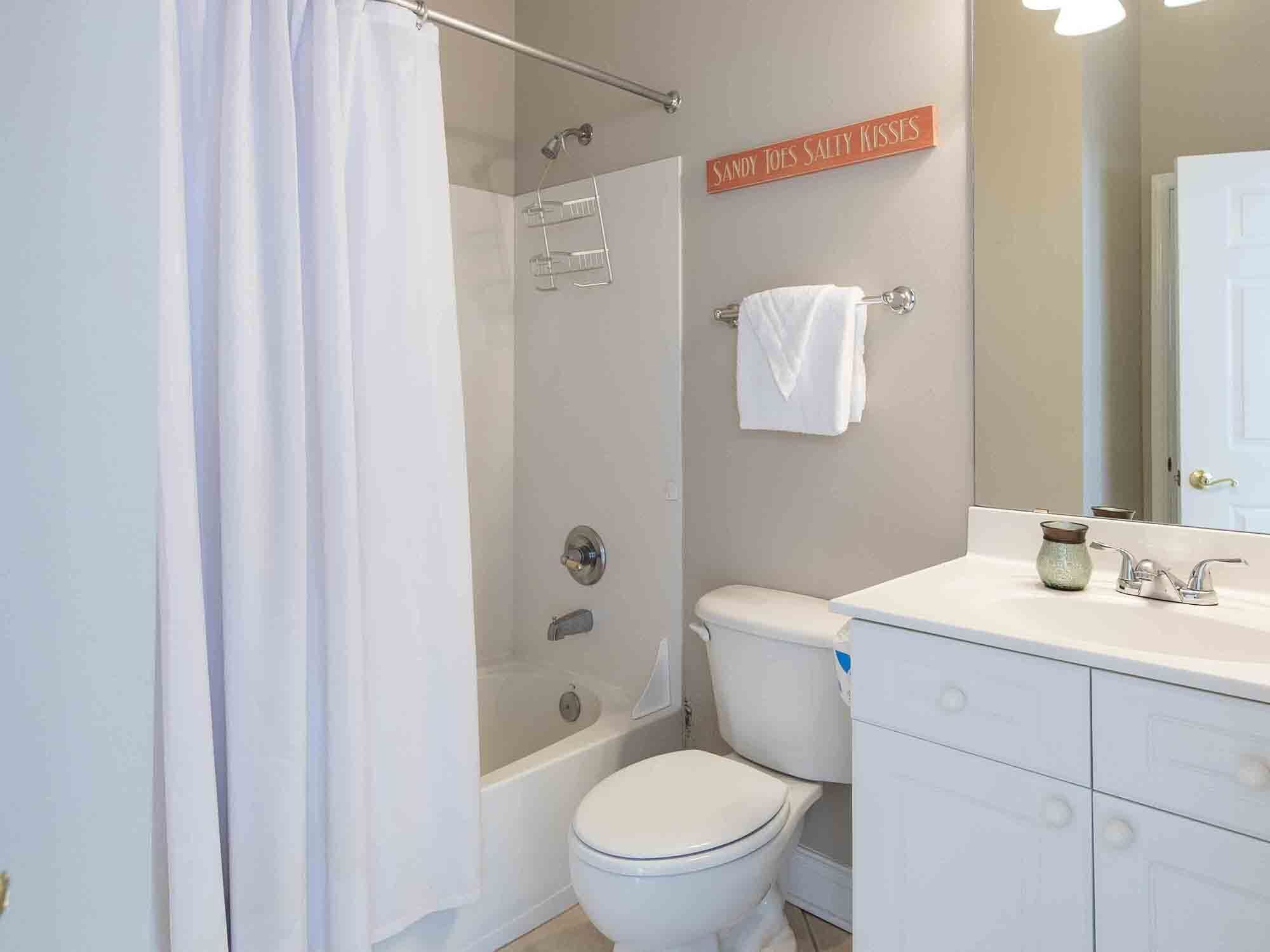 Une salle de bain avec douche, toilettes et lavabo.
