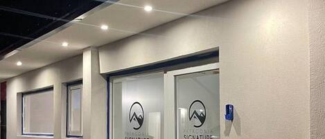 A hotel entrance with two doors labeled "Patagonia Signature Hotel," a textured wall, and a tiled ground.