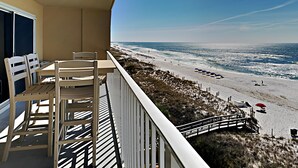 Een balkon met uitzicht op een strand en de oceaan.