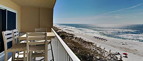 A balcony with a view of a beach and ocean.