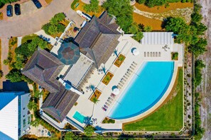 Vue aérienne d’une propriété comprenant une piscine, plusieurs bâtiments et un espace vert environnant.