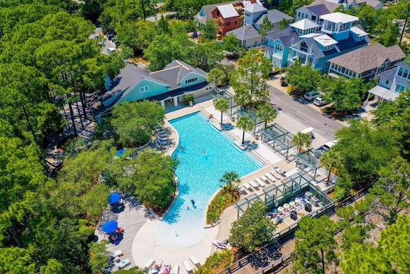 Residents enjoy a serene pool surrounded by lush greenery and accessible via a covered deck.