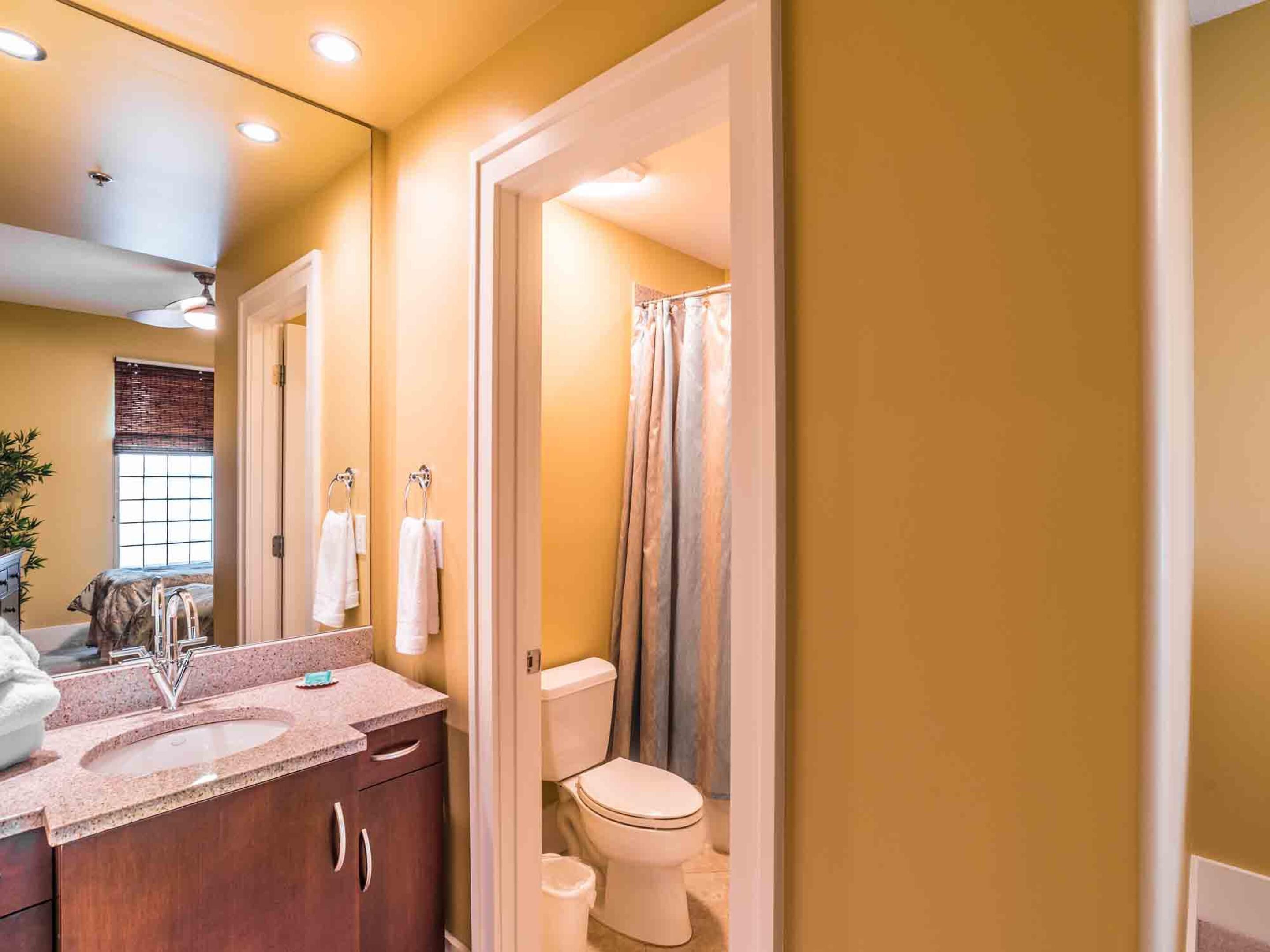 A bathroom with a sink, mirror, and toilet.