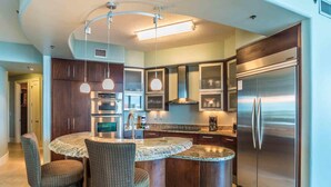 A modern kitchen with a central island, stainless steel appliances, and pendant lighting. - Bella Luna #404 by Southern Vacation Rentals (Orange Beach)