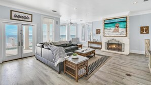 A spacious living room with a grey couch, wooden coffee table, and a fireplace. - Already There by Southern Vacation Rentals (Destin)