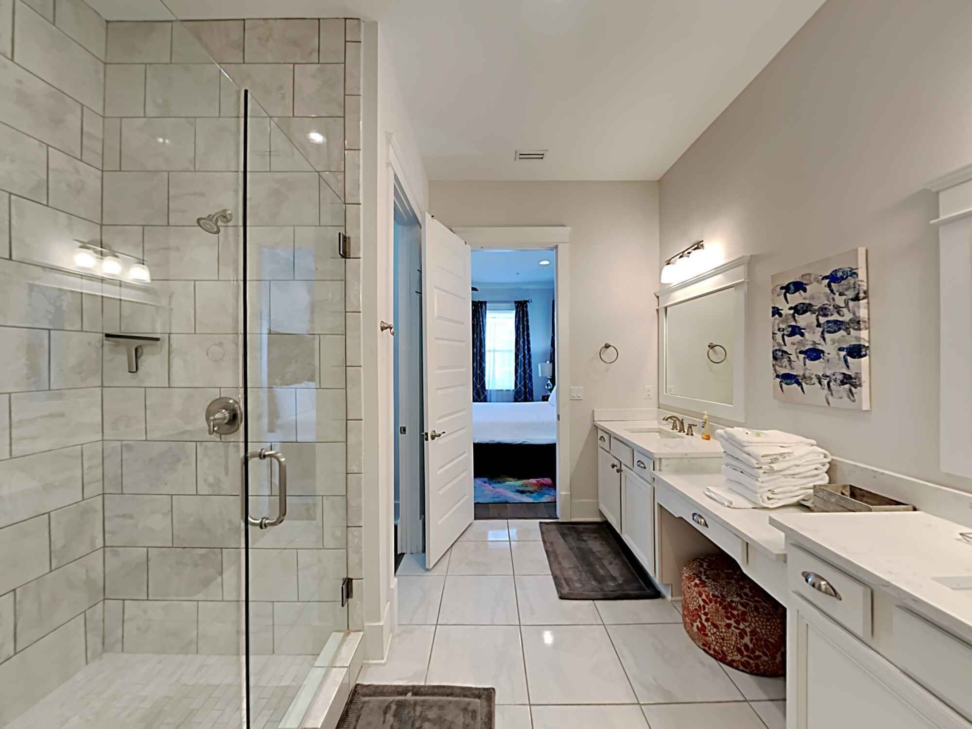 A modern bathroom with a glass-enclosed shower, a double sink vanity, and a large mirror.