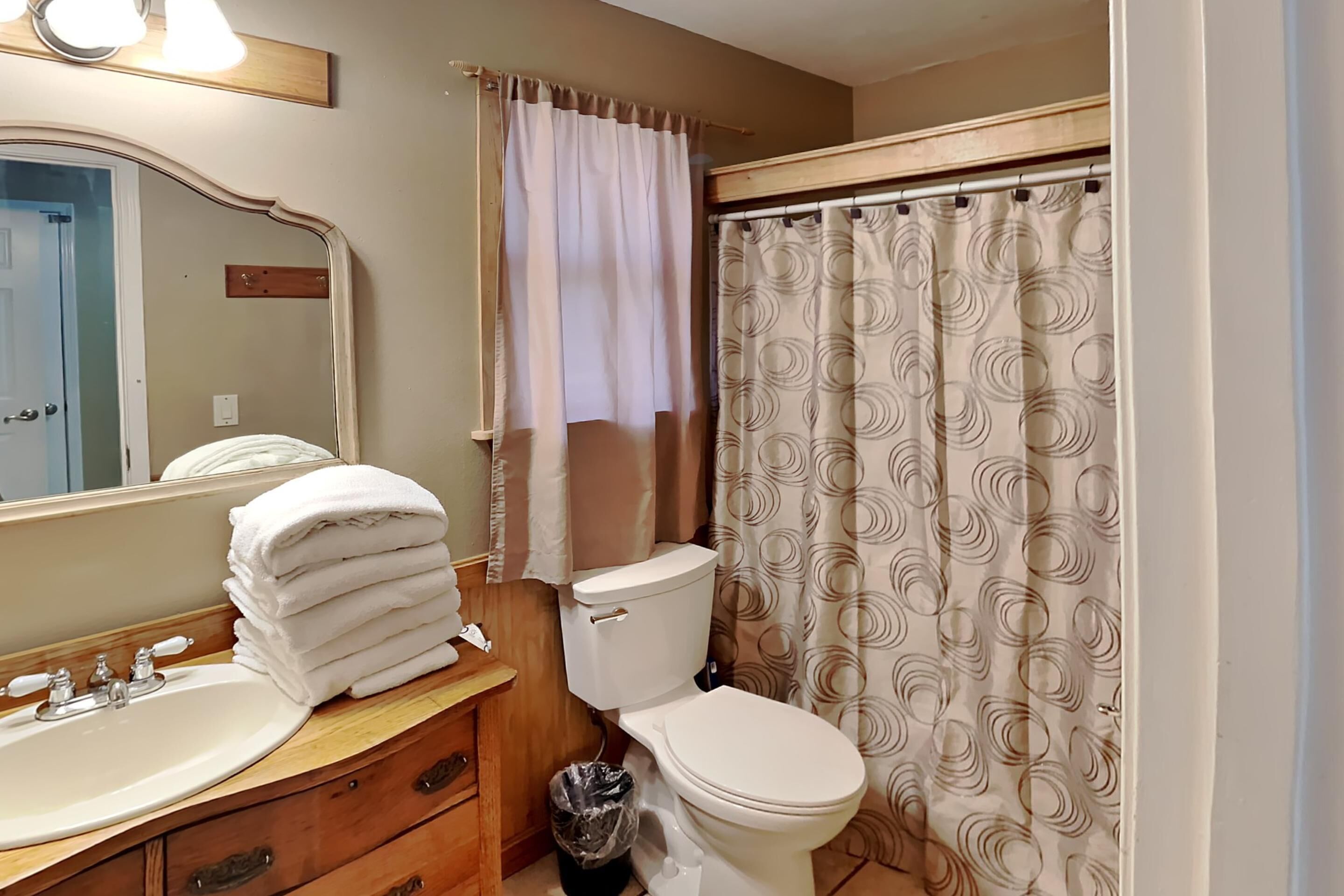 A bathroom with a sink, toilet, and shower curtain.