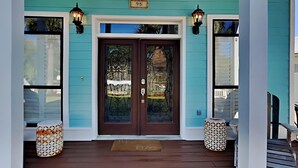 A turquoise house with a dark brown front door, two lantern-style lights, and a number '95' sign above the door. - A Mid-Summer's Night Dream by Southern Vacation Rentals (Destin)