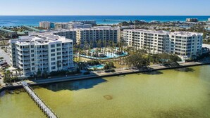 A resort with multiple high-rise buildings, a central pool area, and a view of the ocean.