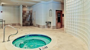 A hotel bathroom with a spa pool, a shower area, and a glass-enclosed door. - Escapes to the Shores #704 by Southern Vacation Rentals (Orange Beach)