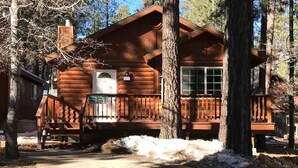 A log cabin with a porch, a chimney, and a door. - Walking Distance to Snow Summit (Big Bear Lake)