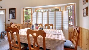 A dining area with a wooden table, chairs, and a shoji screen. - Walking Distance to Snow Summit (Big Bear Lake)