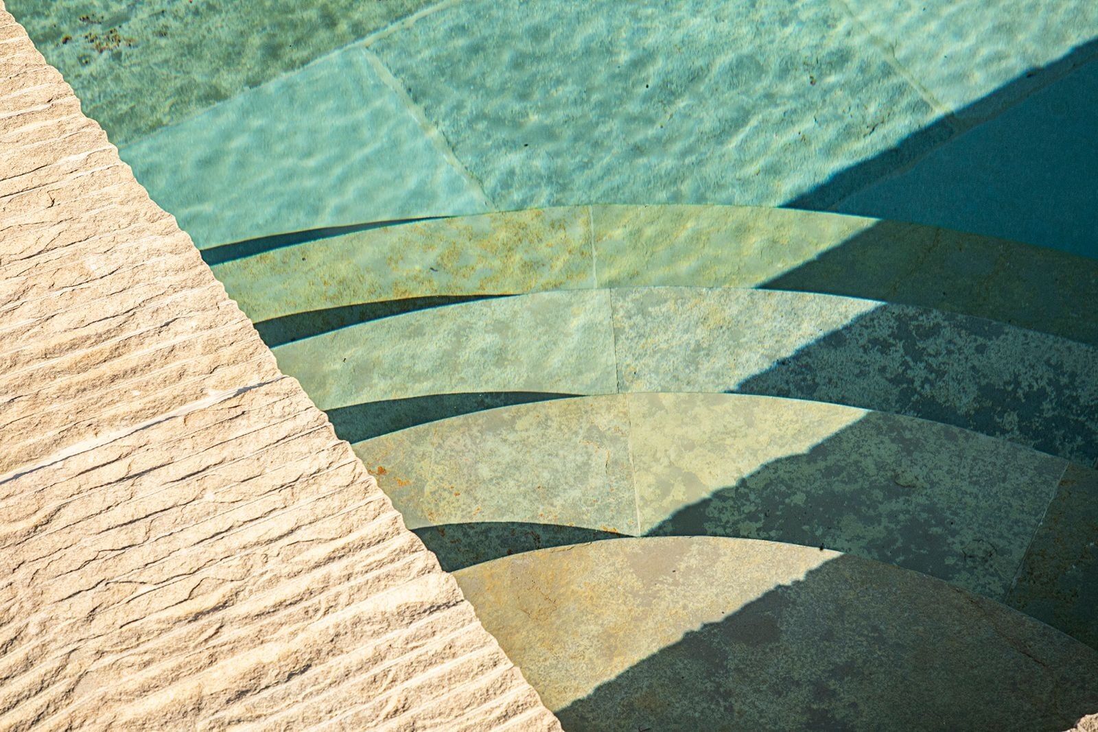 A stone pool with clear water and a stone edge.