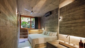 Quarto moderno com cama grande, banco embutido, teto de madeira e janela com cortinas.