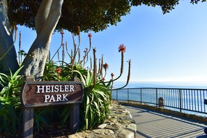 A sign for Heisler Park with a view of the ocean.