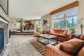 Un salón espacioso con un ventanal grande, una chimenea y una zona de estar acogedora.