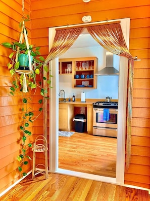 A kitchen with wooden cabinets, a sink, and an oven. - The Europe St Cottage (Baton Rouge)
