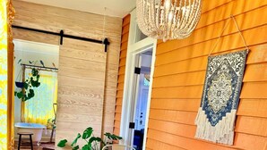 Zona pranzo con tavolo e sedie in legno, lampadario e decorazione murale a motivi.