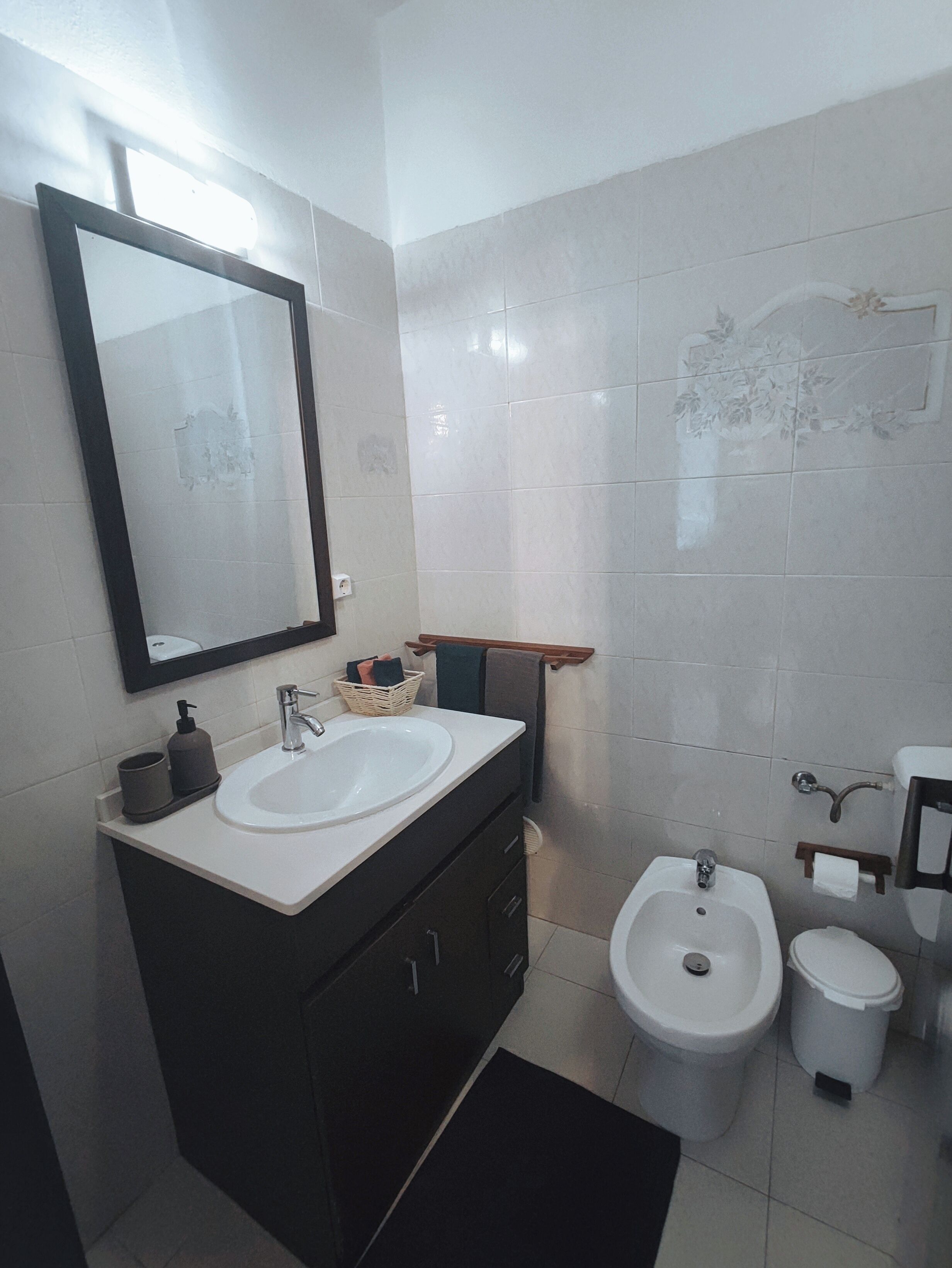Une salle de bain moderne avec deux lavabos, un bidet et des toilettes.