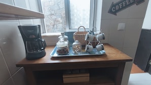 A kitchen counter with a coffee maker, jars, a basket, and a mug rack. - Old Town & 10 min from Beach, Lagos (Lagos)