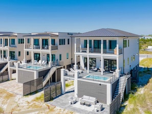 A modern multi-story residential building with a rooftop pool, outdoor seating, and a staircase leading to the upper levels.