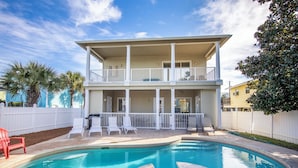 A two-story house with a pool and a covered patio area. - Sandy Retreat by Southern Vacation Rentals (Destin)