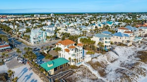 An aerial view of a coastal residential area with houses, a beach, and a road. - Sandy Retreat by Southern Vacation Rentals (Destin)