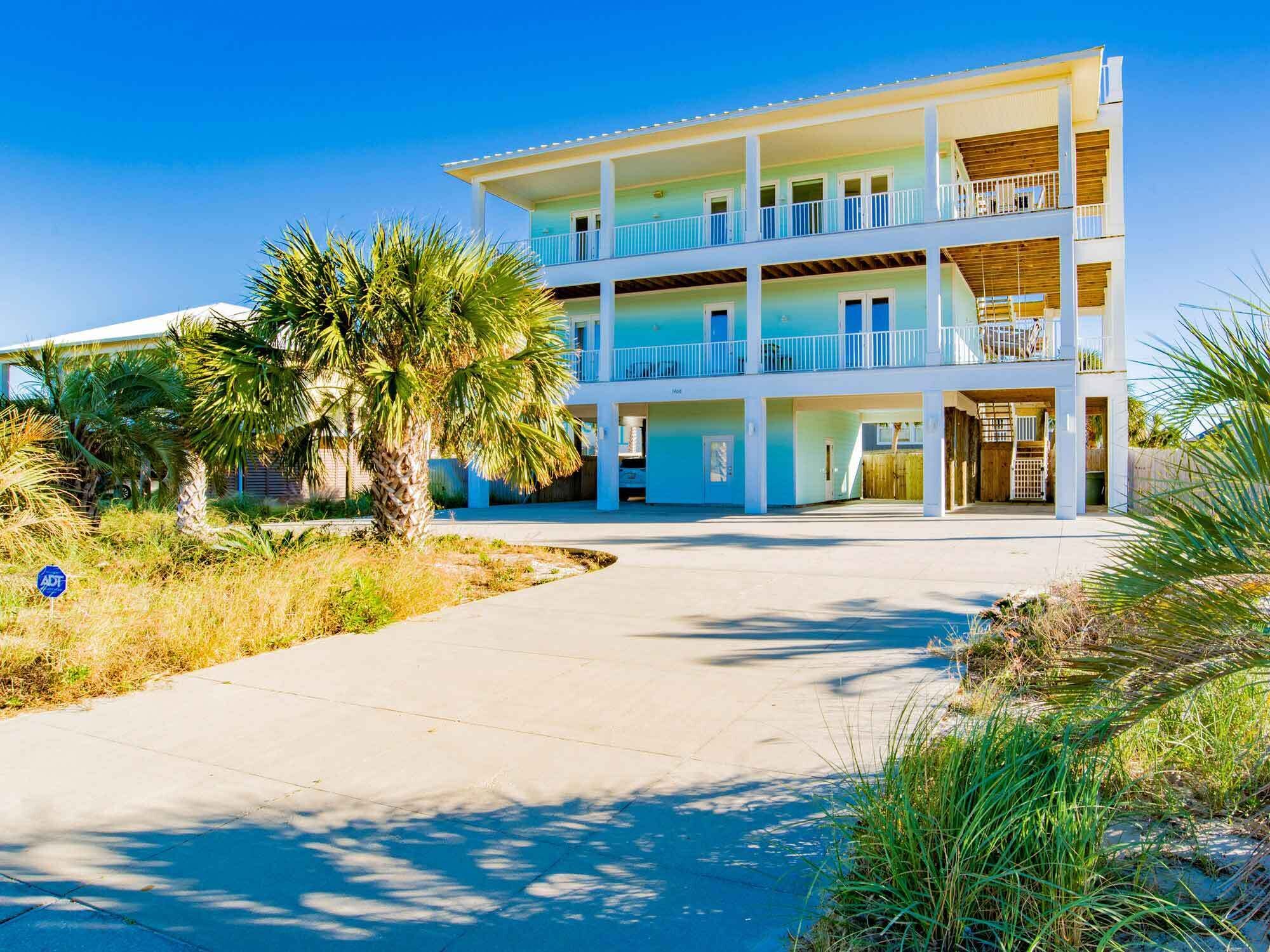A multi-story hotel with a central courtyard, balconies, and a palm tree.