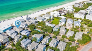 An aerial view of a coastal residential area with houses, a beach, and a swimming pool. - Magnolia House by Southern Vacation Rentals (Santa Rosa Beach)