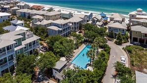 A coastal residential area with modern houses, a swimming pool, and a view of the ocean. - Magnolia House by Southern Vacation Rentals (Santa Rosa Beach)