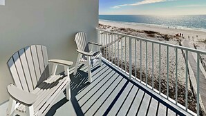 A balcony with two Adirondack chairs overlooking a beach. - Tropic Isle #403 by Southern Vacation Rentals (Gulf Shores)