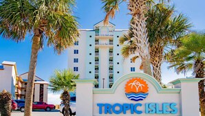 A sign for Tropic Isles with the number 433, surrounded by palm trees and a building in the background. - Tropic Isle #403 by Southern Vacation Rentals (Gulf Shores)