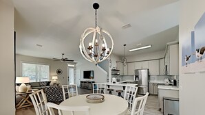 A modern kitchen with white cabinetry, a central island, and a chandelier. - Sunny Days by Southern Vacation Rentals (Miramar Beach)