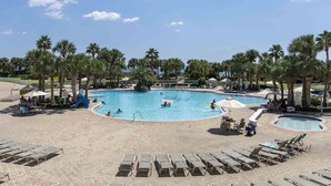 Ein Poolbereich mit mehreren Schwimmbecken, Liegestühlen und Palmen.