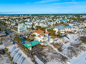 Stunning coastal homes with modern and traditional styles, featuring balconies and flat roofs, set amidst a serene beachside setting.