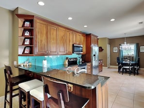 Enjoy cooking in this well-equipped kitchen with a central island, dining area, and ample natural light.