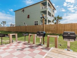 A patio with a checkered floor and barbecue grills.