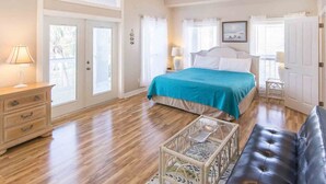 Un dormitorio con cama, mesitas de noche, cómoda y un banco.