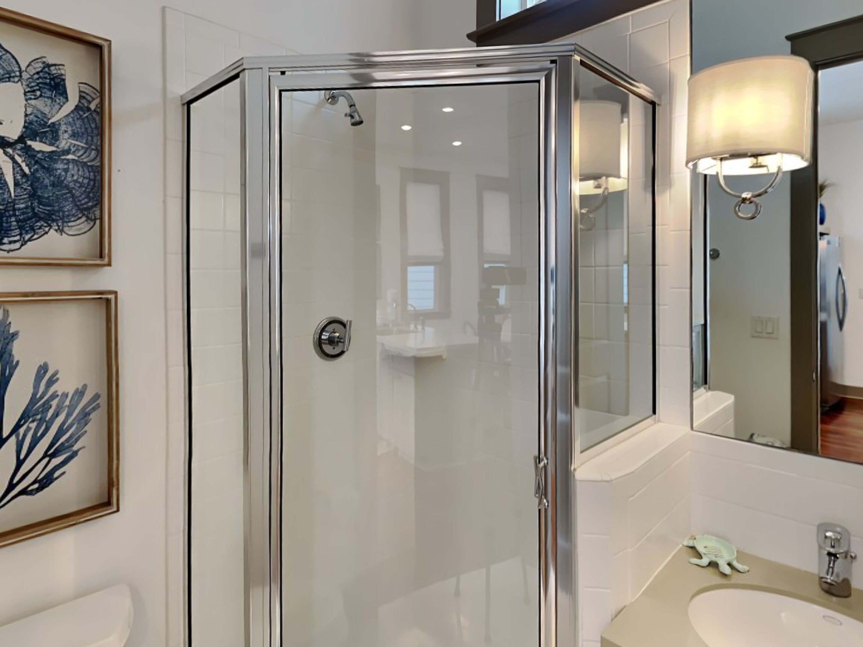 Une salle de bain moderne avec une douche à parois de verre, un lavabo et un miroir.