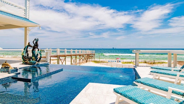 A pool area with a view of the ocean, a wooden deck, and lounge chairs. - Mural Manor on Ponce by Southern Vacation Rentals (Gulf Shores)