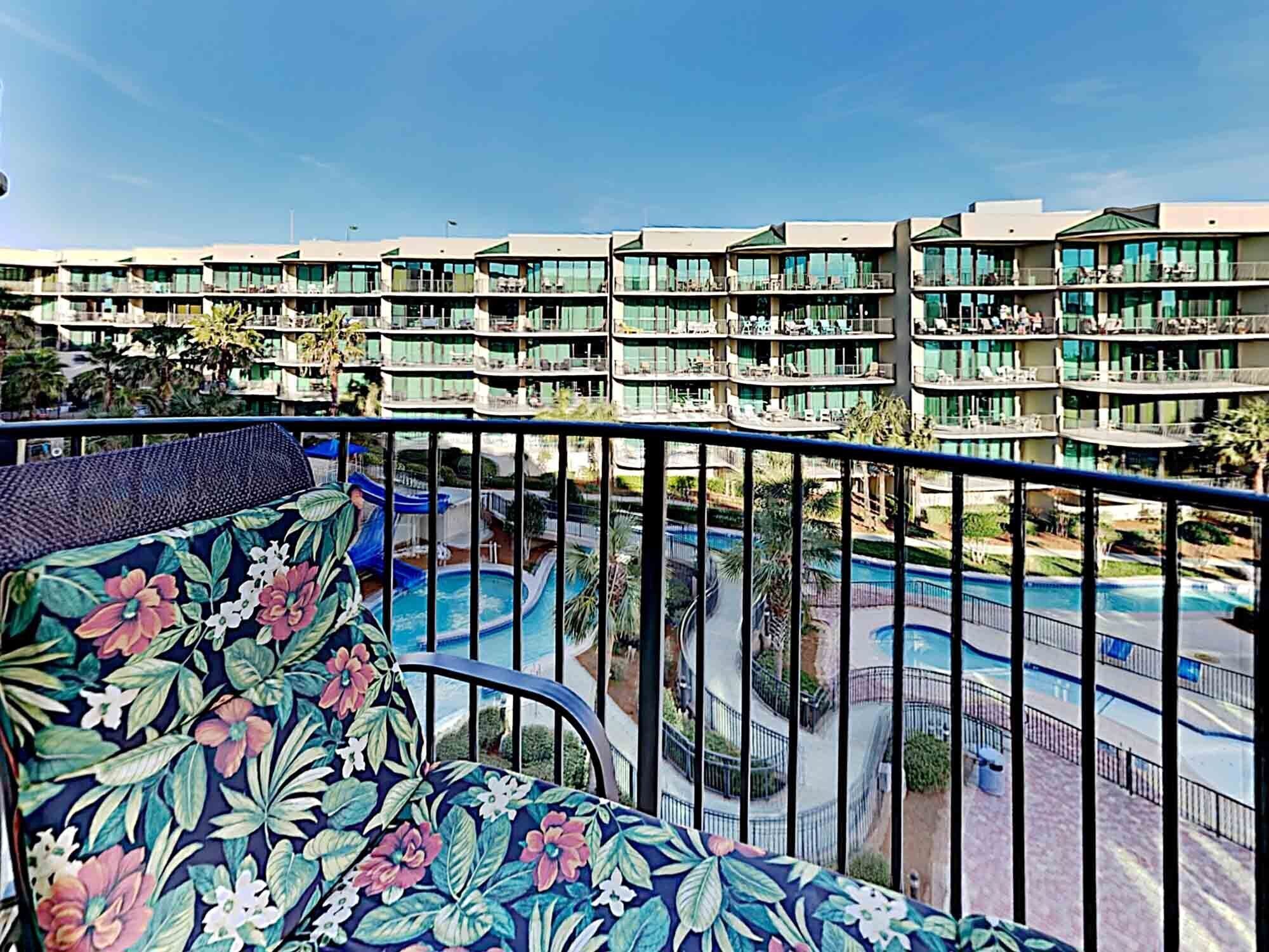 Ein Hotel mit mehreren Balkonen, einem Schwimmbad und Blick auf einen tropischen Garten.