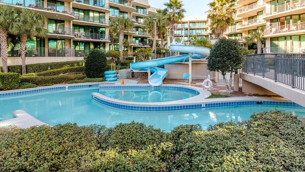 A hotel with a pool, a water slide, and multiple balconies. - Phoenix on the Bay by Southern Vacation Rentals (Orange Beach)
